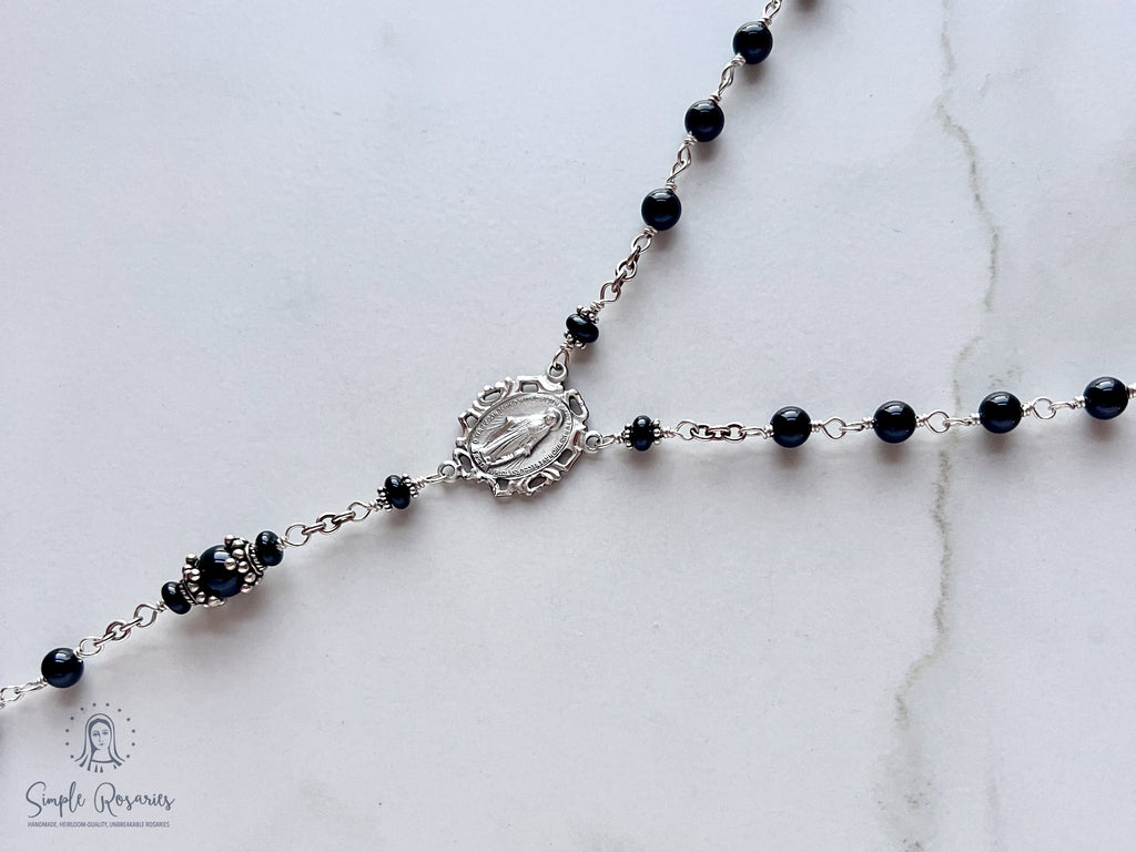 Handmade, heirloom-quality rosary featuring unbreakable onyx beads and durable solid sterling silver construction, designed for lasting beauty and spiritual significance